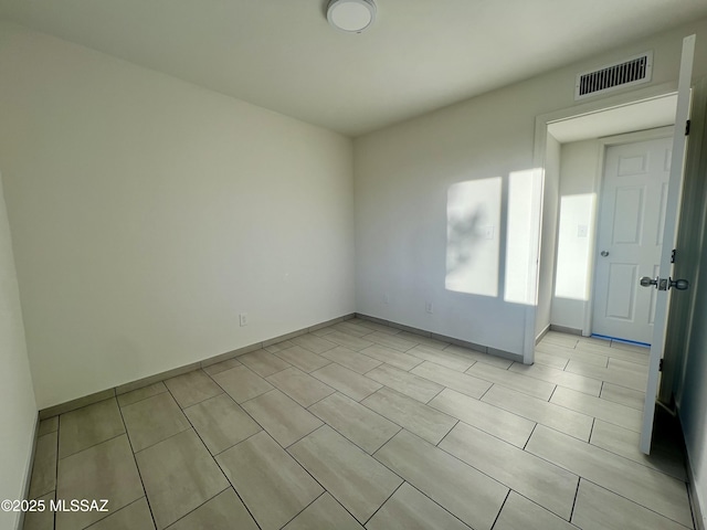 empty room with baseboards and visible vents