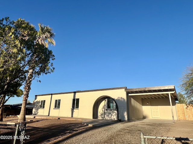 view of front of property with an attached carport and fence