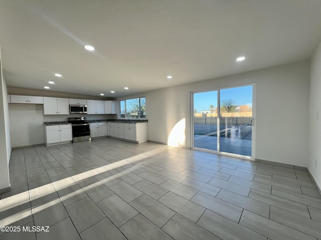 kitchen featuring light tile patterned flooring, appliances with stainless steel finishes, dark countertops, white cabinets, and recessed lighting
