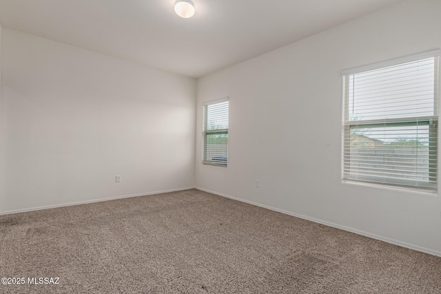 unfurnished room with carpet flooring and baseboards