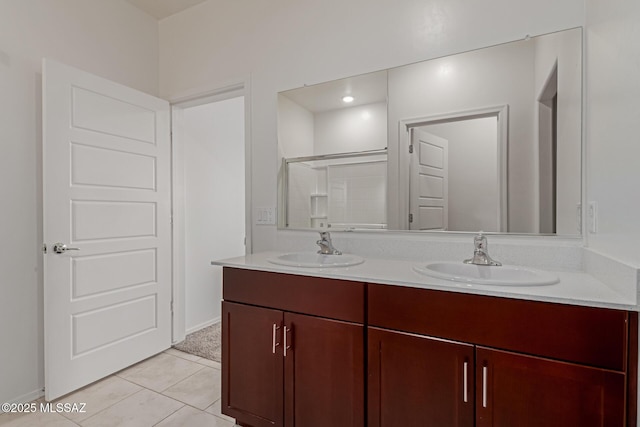 bathroom with double vanity, a sink, tile patterned floors, and a shower stall