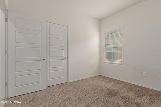 unfurnished bedroom featuring carpet flooring and baseboards