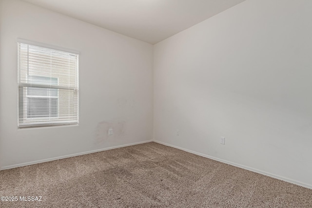 carpeted spare room with baseboards