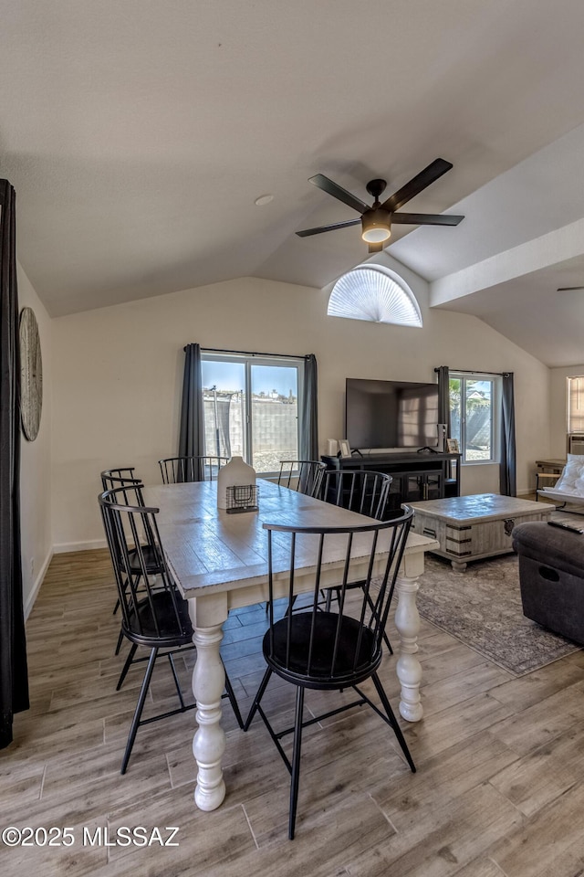 dining area featuring wood finished floors, baseboards, lofted ceiling, and ceiling fan