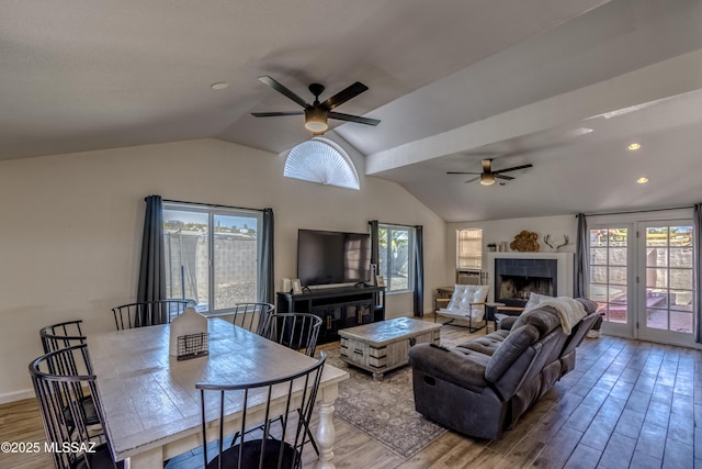 living area with lofted ceiling, wood finished floors, and a ceiling fan
