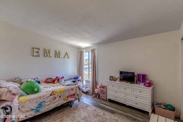 bedroom with a textured ceiling and wood finished floors