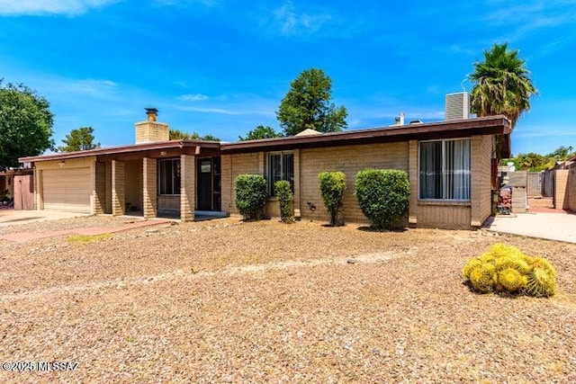 view of front of home featuring a chimney, a garage, and concrete driveway