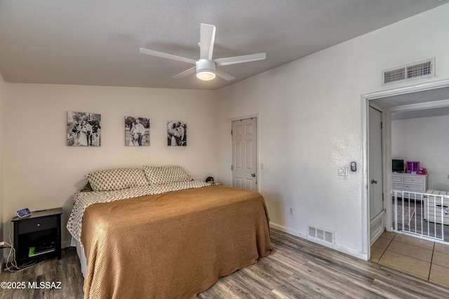 bedroom featuring a ceiling fan, wood finished floors, baseboards, and visible vents