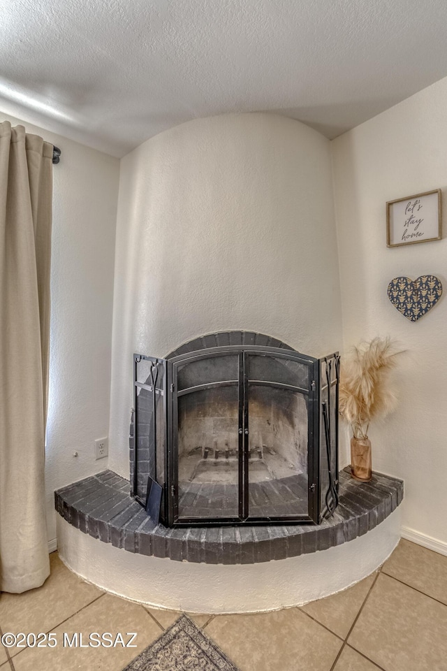 room details featuring a textured ceiling and a fireplace with raised hearth