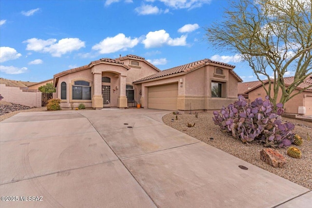 660 W Via Rosaldo, Green Valley, AZ 85614 - mediterranean / spanish-style home featuring a tiled roof, stucco siding, fence, an attached garage, and driveway