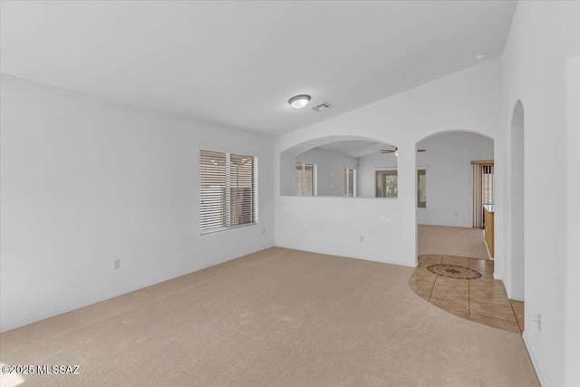 660 W Via Rosaldo, Green Valley, AZ 85614 - carpeted spare room featuring arched walkways, vaulted ceiling, tile patterned flooring, and visible vents