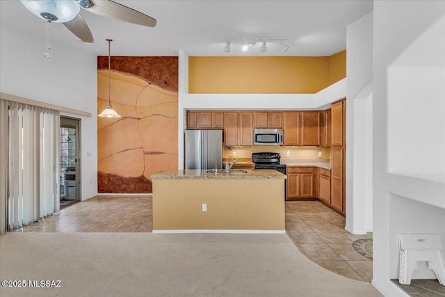 660 W Via Rosaldo, Green Valley, AZ 85614 - kitchen with a center island with sink, hanging light fixtures, a high ceiling, and stainless steel appliances