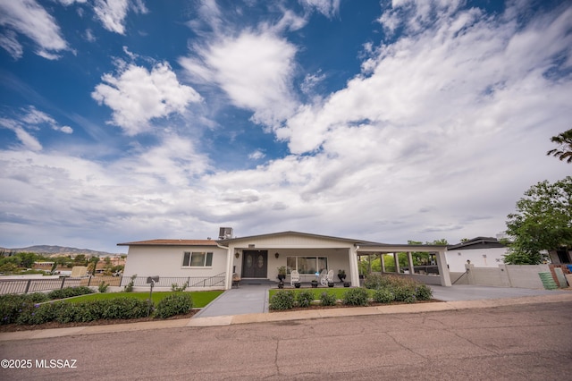 view of front of property with driveway, an attached carport, a gate, and a fenced front yard