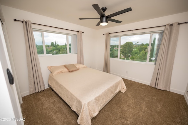 bedroom featuring multiple windows, ceiling fan, baseboards, and carpet flooring