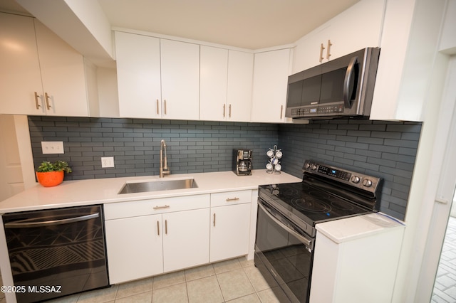 kitchen featuring light countertops, a sink, tasteful backsplash, and appliances with stainless steel finishes