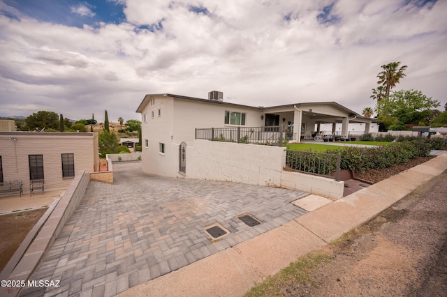 exterior space with stucco siding and fence