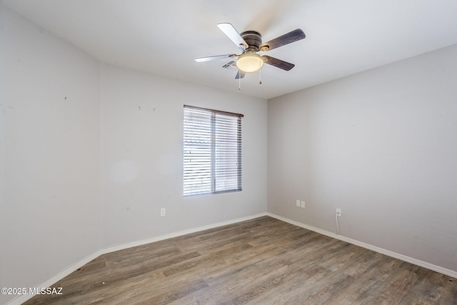 empty room with wood finished floors, baseboards, and ceiling fan