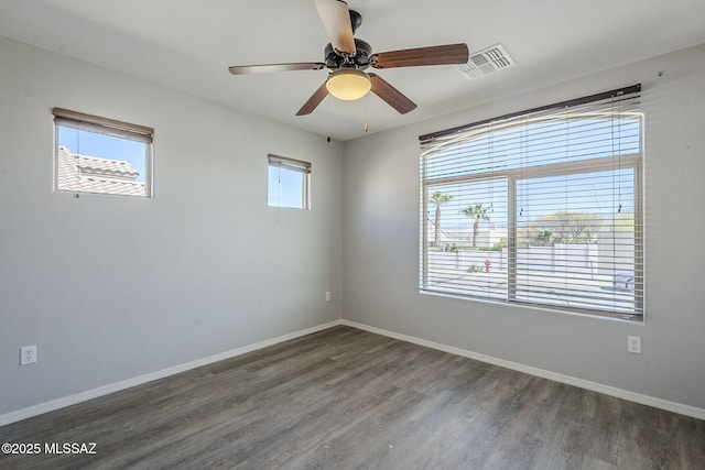 empty room featuring baseboards, wood finished floors, visible vents, and a ceiling fan