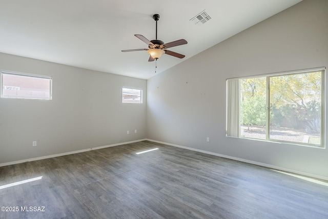 unfurnished room featuring baseboards, visible vents, lofted ceiling, a ceiling fan, and wood finished floors
