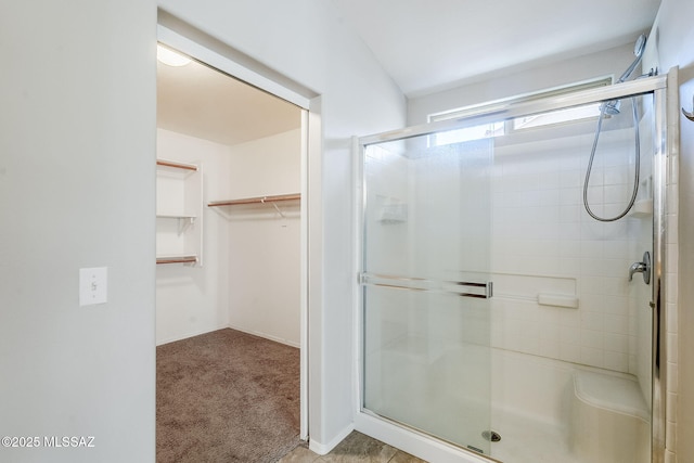 bathroom with a shower stall and a spacious closet