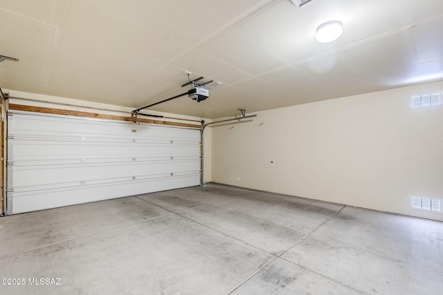 garage featuring a garage door opener and visible vents