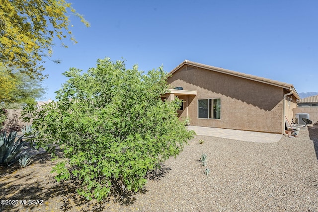 view of home's exterior with stucco siding and a patio