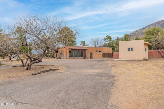 5374 E Spring Rd, Hereford, AZ 85615 - pueblo-style home featuring stucco siding, fence, and a mountain view