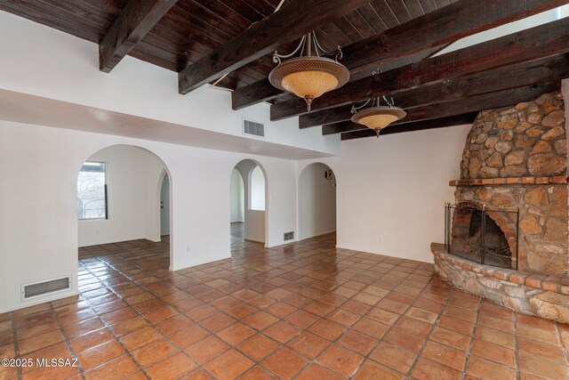 5374 E Spring Rd, Hereford, AZ 85615 - unfurnished living room with a fireplace, visible vents, and wooden ceiling