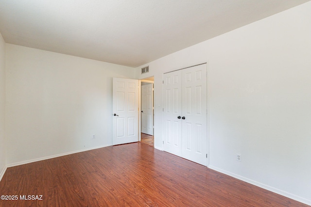 5374 E Spring Rd, Hereford, AZ 85615 - unfurnished bedroom featuring baseboards, visible vents, a closet, and wood finished floors