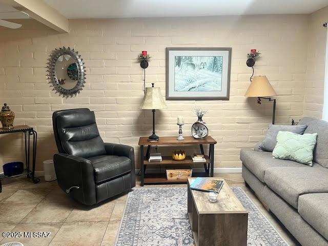 living room featuring brick wall and light tile patterned floors