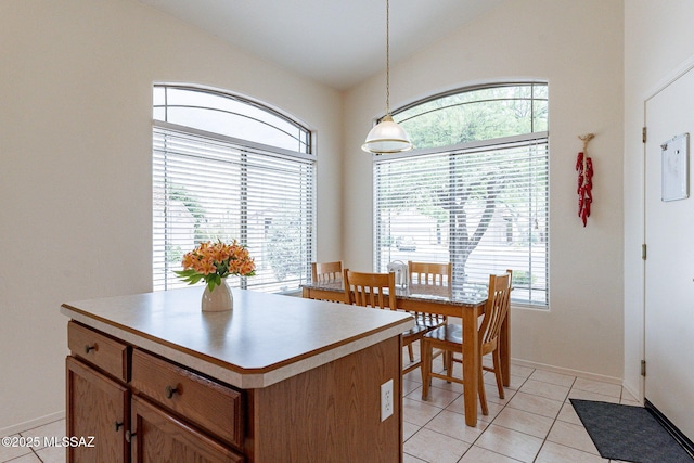 dining room featuring baseboards, light tile patterned flooring, and vaulted ceiling