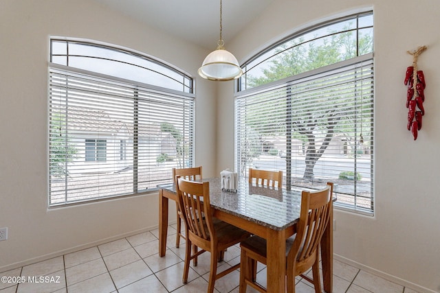 dining room featuring baseboards, light tile patterned flooring, and a wealth of natural light