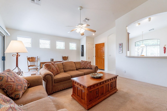 living room with arched walkways, a ceiling fan, and visible vents