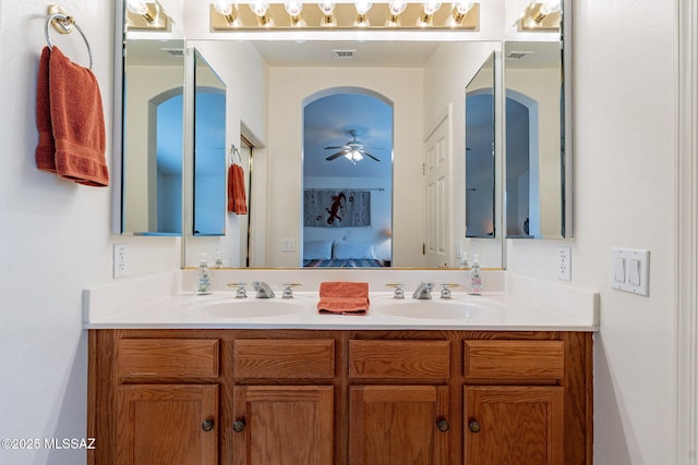 ensuite bathroom featuring a sink, ceiling fan, double vanity, and visible vents