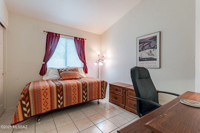 bedroom with light tile patterned flooring and lofted ceiling
