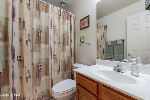 bathroom with vanity, a shower with shower curtain, toilet, and visible vents