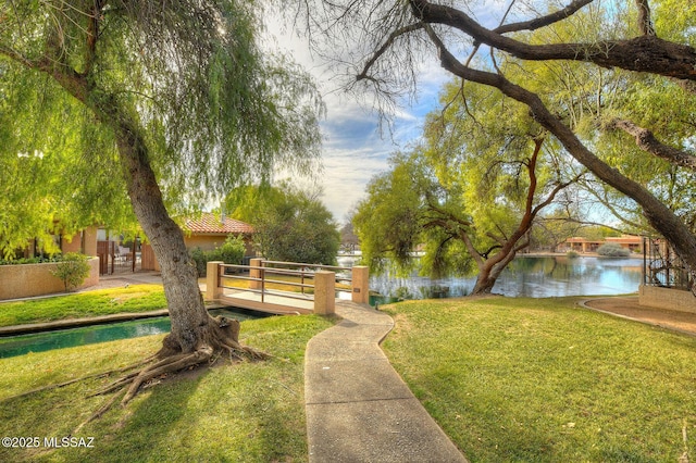 view of property's community with a water view and a yard