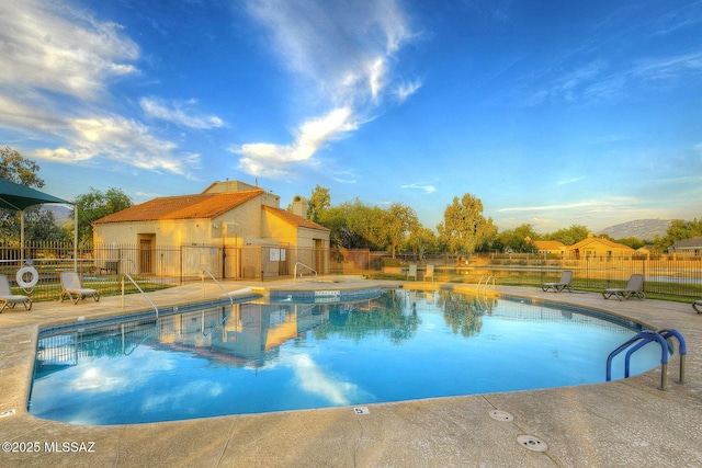 community pool featuring fence and a patio area
