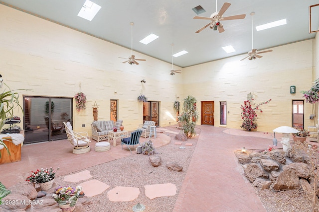32551 S Moyza Ranch Rd, Amado, AZ 85645 - miscellaneous room with visible vents, a skylight, a ceiling fan, brick floor, and a high ceiling