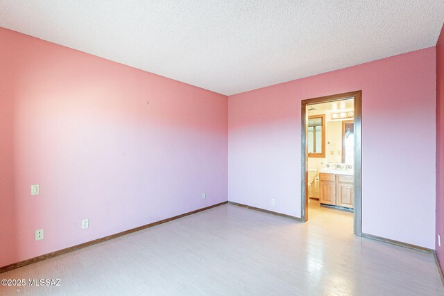 32551 S Moyza Ranch Rd, Amado, AZ 85645 - spare room featuring baseboards, light wood finished floors, and a textured ceiling