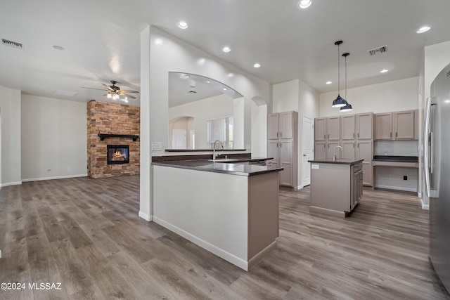 kitchen with visible vents, dark countertops, stainless steel refrigerator, and a ceiling fan
