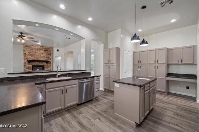 kitchen featuring dishwasher, a sink, dark countertops, and visible vents