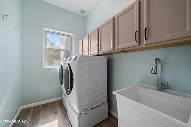 laundry room featuring a sink, separate washer and dryer, baseboards, visible vents, and cabinet space