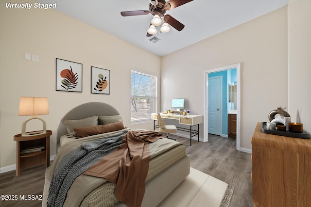 bedroom with baseboards, connected bathroom, visible vents, and wood finished floors