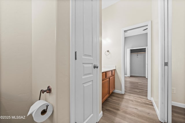 bathroom with vanity, baseboards, and wood finished floors