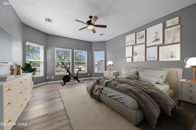 bedroom with a ceiling fan, wood finished floors, baseboards, and visible vents