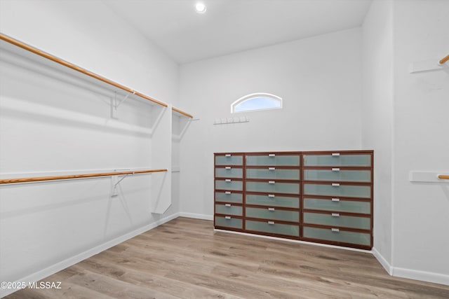 walk in closet with wood finished floors