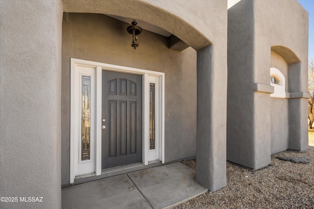 view of exterior entry featuring stucco siding