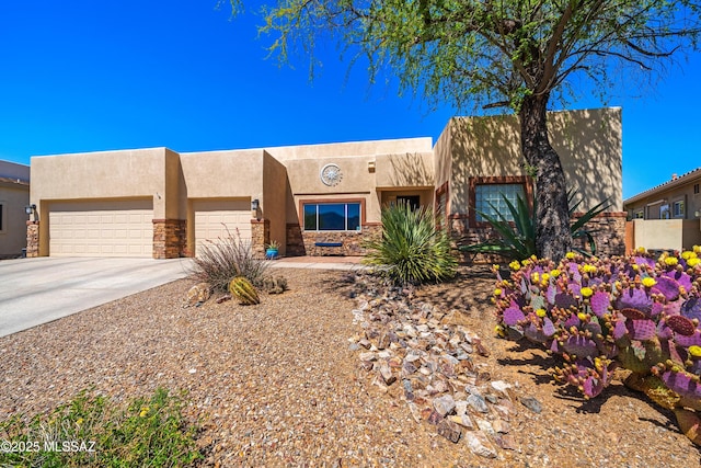 southwest-style home featuring an attached garage, stone siding, driveway, and stucco siding