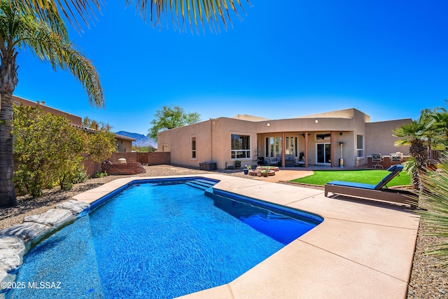 view of swimming pool featuring a patio, a yard, a fenced backyard, and a fenced in pool